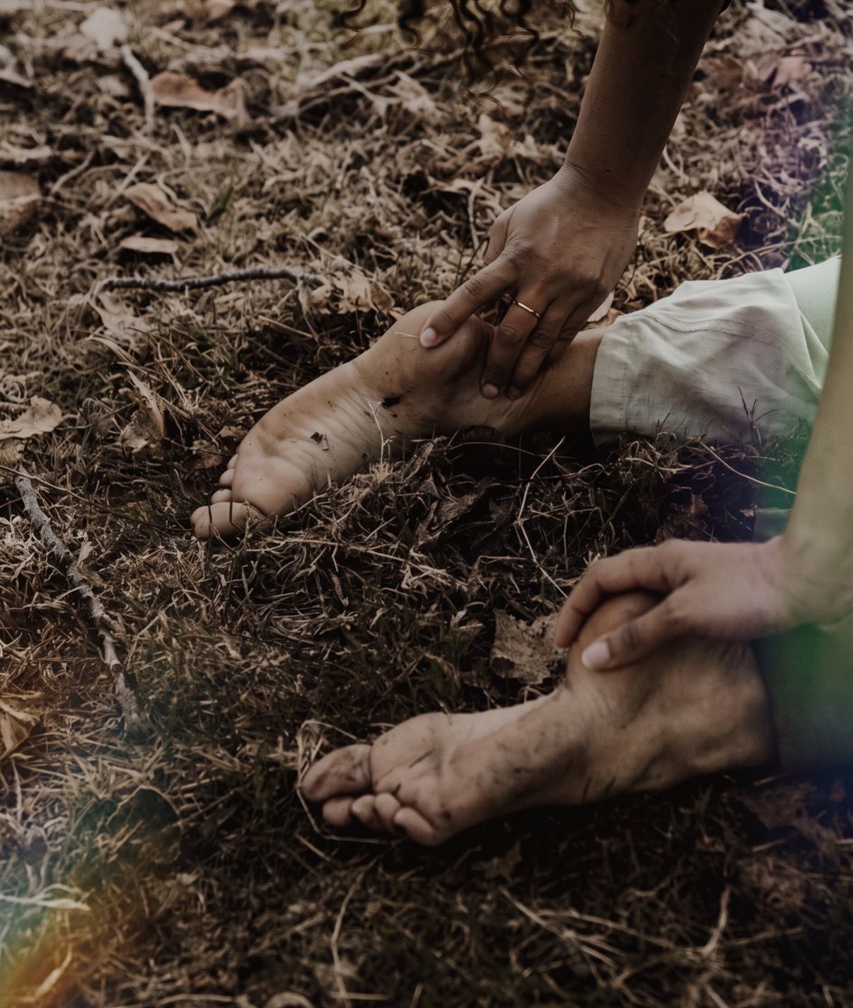 Hands on bare feet on the earth